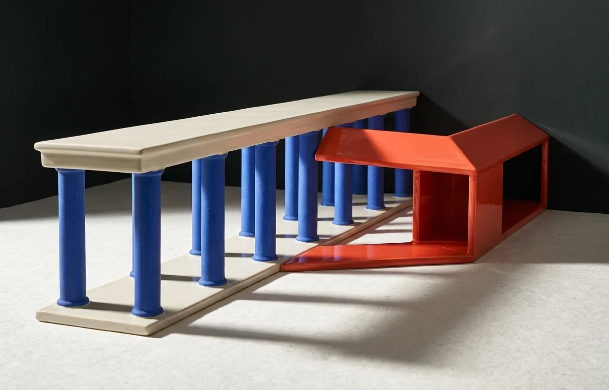 Крытая белая галерея на синих колоннах ведет вперед, а коралловый боковой коридор уходит в темное пространство